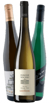 Drei Weinflaschen stehen nebeneinander, in der Mitte das beige Etikett "Domäne Wachau Riesling Smaragd 2023 Singerriedel". Auf jeder Seite befinden sich grüne Flaschen mit einzigartigen Verschlüssen - Teil des Riesling Selection Pakets | 6 Fl. | GRATIS VERSAND*.